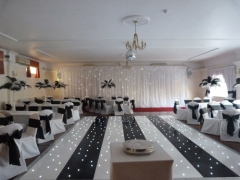 Linen covers with black taffeta and feather centrepieces