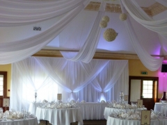 Grecian-backdrop-white-uplighters-and-non-swag-front-table